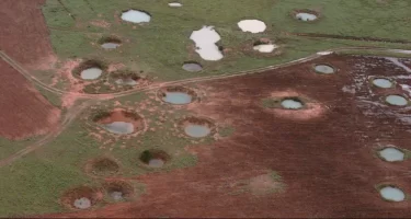 What appears to be ponds are actually water-filled bomb craters from the Vietnam War era, as seen from a helicopter in 1997 near the northeastern Laotian village of Sam Neau.