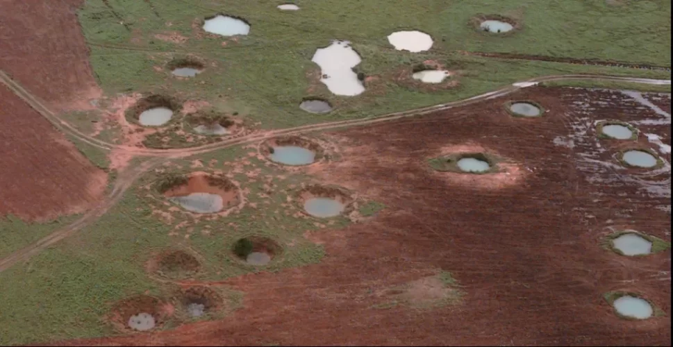 What appears to be ponds are actually water-filled bomb craters from the Vietnam War era, as seen from a helicopter in 1997 near the northeastern Laotian village of Sam Neau.